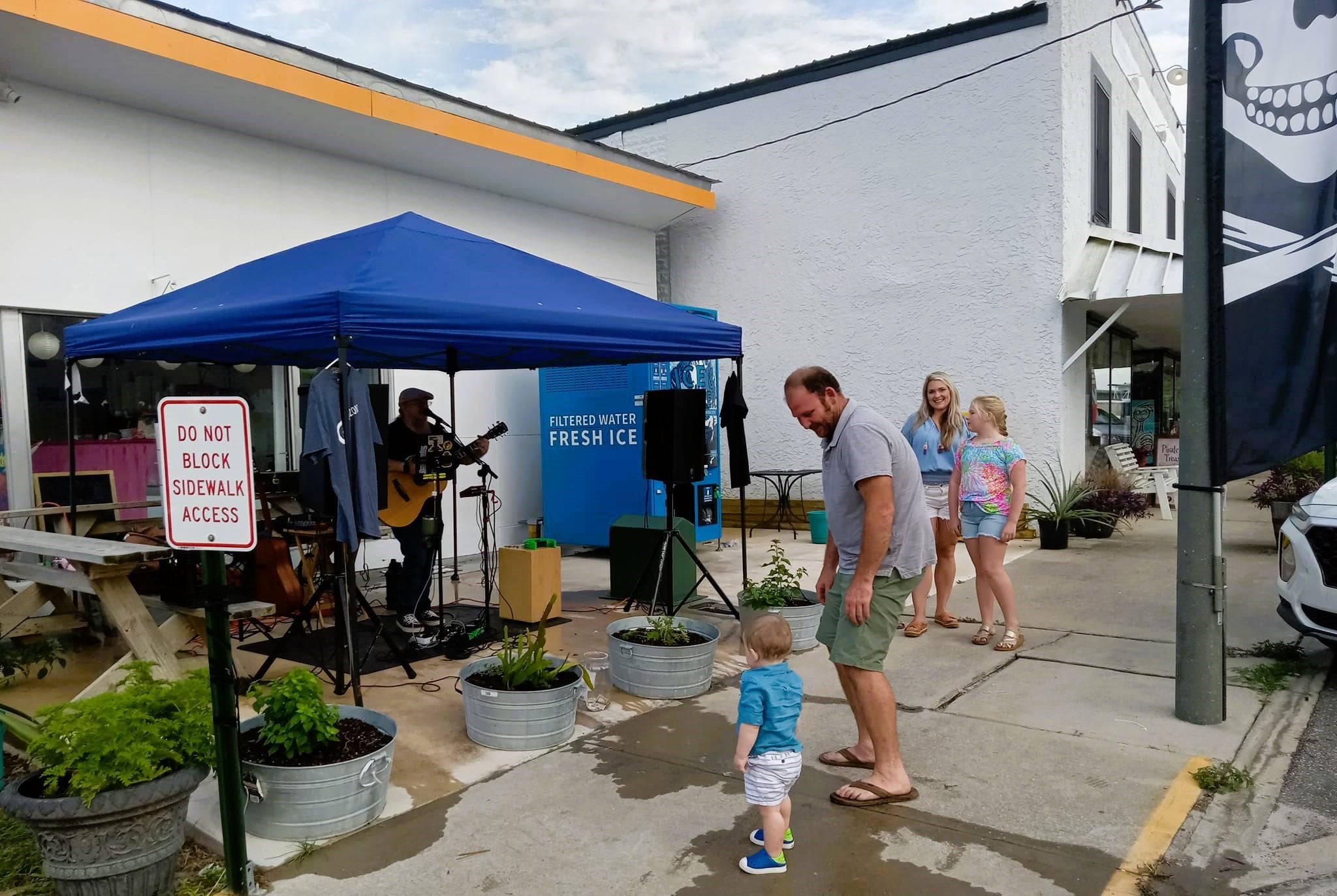 A family listens to a musician on the patio of Taste of Korea restaurant