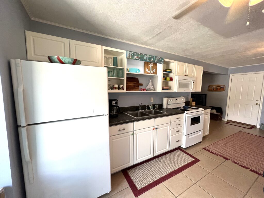 A kitchenette with fridge, oven and cabinets